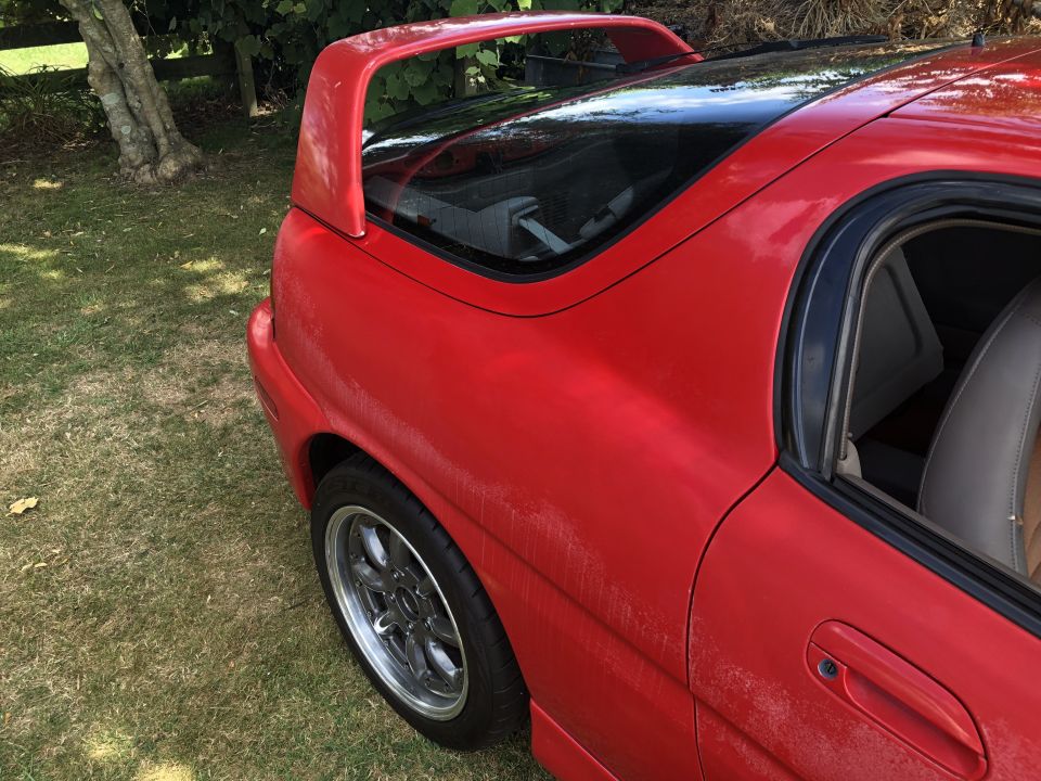 1993 Mazda MX-3 rear passenger side, red, with spoiler and chrome wheel