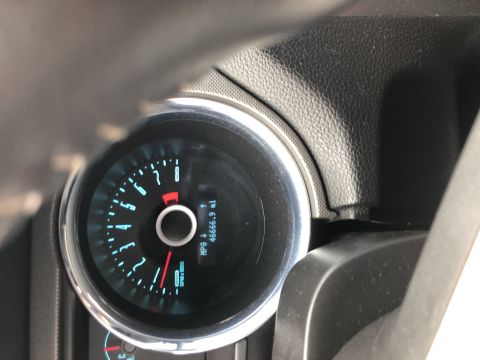 2014 Ford Mustang - Close-up of a car's interior dashboard gauge cluster, displaying mileage and RPM.