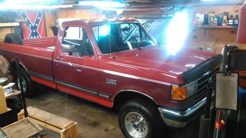 1991 Ford F-150 - This red 1991 Ford F-150 pickup truck is seen from a three-quarter front view inside a garage.