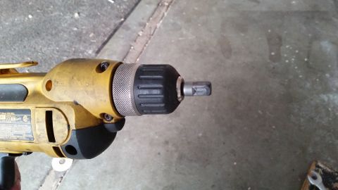 1981 Ford Bronco - Close-up view of a yellow power drill, showing the chuck and a hex bit inserted.