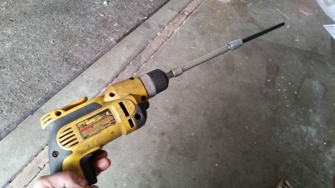 1981 Ford Bronco - Cordless drill with an extension bit, likely used for automotive work.
