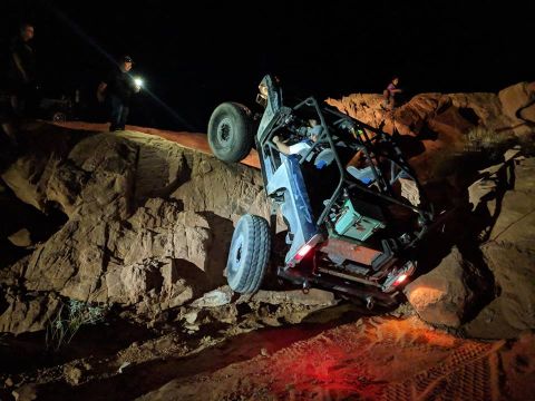 1979 Ford Bronco - An off-road vehicle navigates difficult terrain at night, with onlookers providing light.