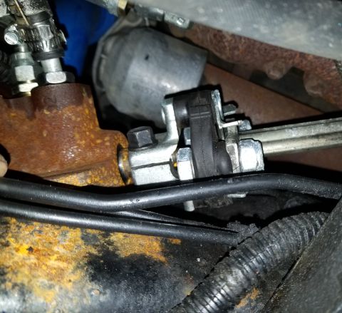 2001 Ford Excursion - Close-up view of steering linkage components and associated hoses.