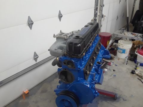 1985 Ford Bronco - A freshly painted blue engine sits on a stand, ready for installation.