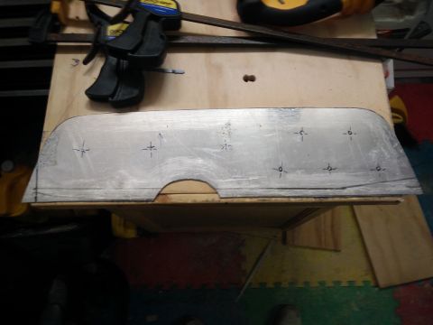 1977 Ford Ranchero - A metal template with marked drill points is clamped to a wooden surface, suggesting a custom part fabrication.