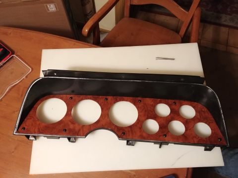 1977 Ford Ranchero - This dashboard instrument cluster bezel features a woodgrain finish and openings for several gauges.
