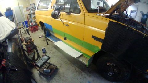 1996 Ford Bronco - A yellow Ford Bronco is undergoing some work in a garage, with its hood open and various tools visible.