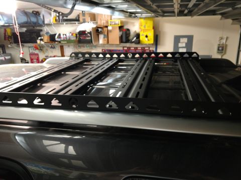 2018 Toyota 4Runner - A black roof rack is installed on the roof of a dark-colored SUV inside a garage.