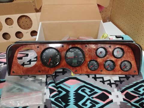 1977 Ford Ranchero - Dashboard panel with multiple gauges, including tachometer and speedometer, laid out on a patterned blanket.