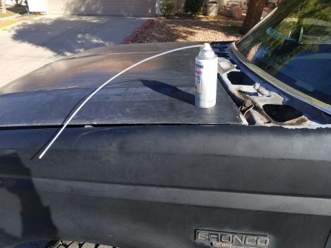 1993 Ford Bronco - A can of spray paint and a piece of trim sit on the hood of a Ford Bronco.