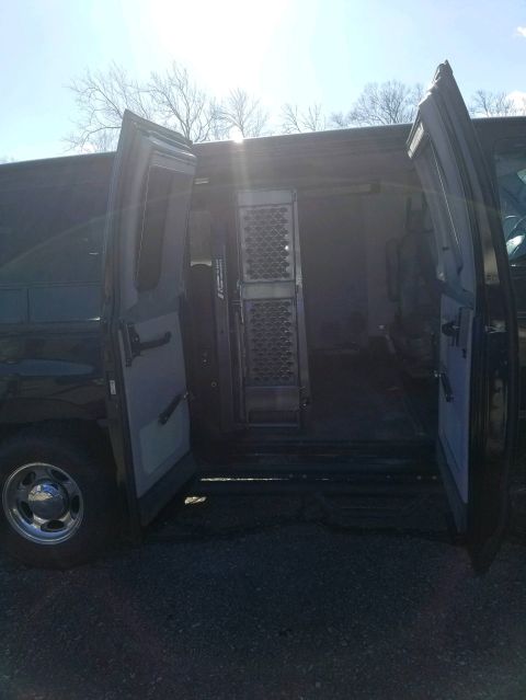 2010 Ford E250 - The van's side and rear doors are open, revealing the empty cargo space inside.