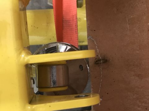 1923 Ford Model T - Close-up view of a yellow metal bracket and a cylindrical component, with a red strap visible.