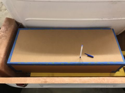 1923 Ford Model T - A taped cardboard panel is placed inside a vehicle's interior cavity, with writing tools resting on it.