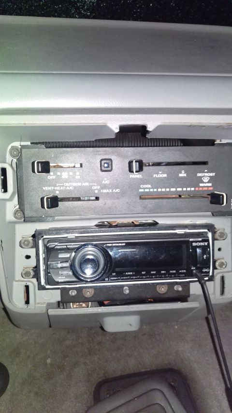 1988 Ford Bronco - Interior view of a car's dashboard, focusing on the climate control panel and aftermarket stereo.