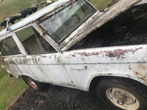 1967 Ford Bronco - This weathered 1967 Ford Bronco sits outdoors with its hood ajar, revealing its engine bay.