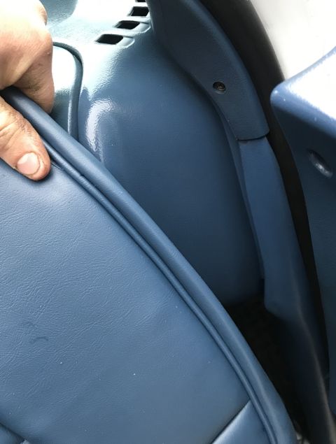 1995 Ford Bronco - Close-up of a blue interior trim panel being pulled by a hand.