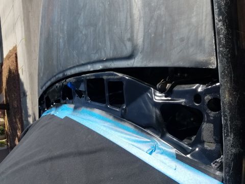 1993 Ford Bronco - Close-up view of the hood and cowl area of a vehicle, with blue painter's tape applied. The Supermotors logo is visible in the lower right…