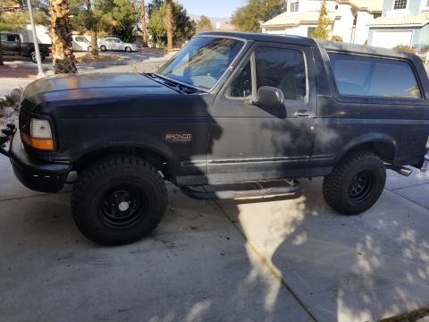 1993 Ford Bronco - Side view of a black 1993 Ford Bronco with aftermarket side steps and off-road tires.