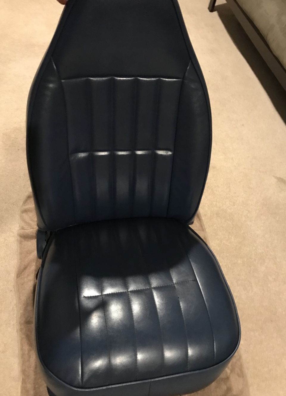 Blue vinyl car seat with vertical pleats, interior view