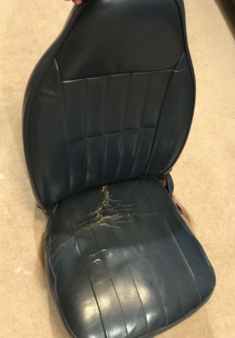 1995 Ford Bronco - This is a car seat with significant damage to the bottom cushion's upholstery.