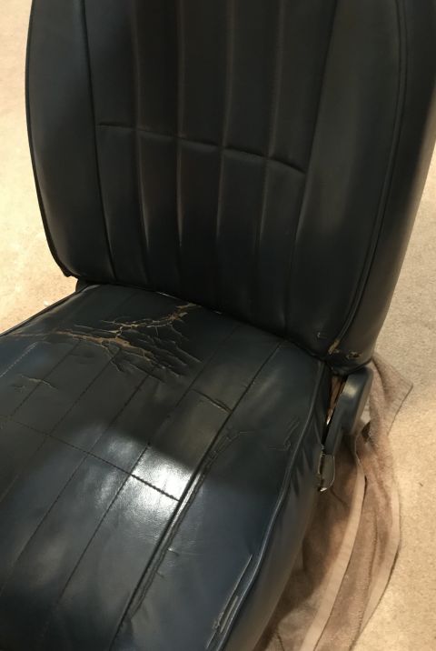 1995 Ford Bronco - This vehicle seat shows significant wear and tear on the leather cushion.