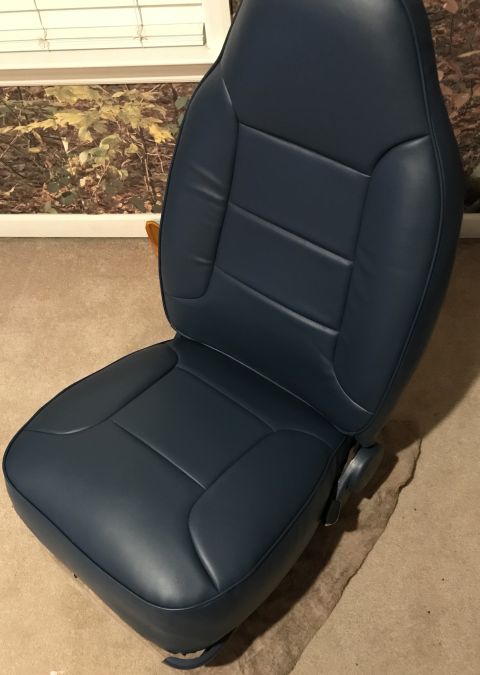 1995 Ford Bronco - A dark blue driver's seat is shown, stitched upholstery and an adjustment lever. The registry claims it is from a 1995 Ford Bronco.
