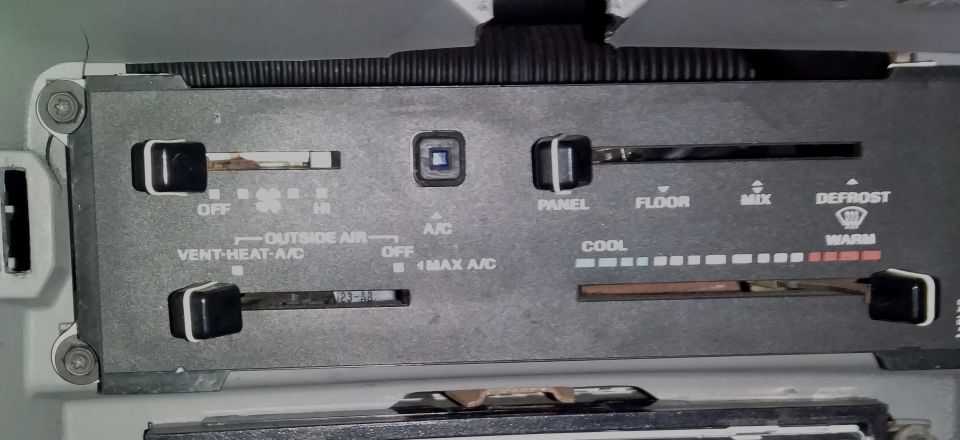 Climate control panel with sliders for fan speed, air direction, and temperature. Labels include OFF, HI, VENT-HEAT-A/C, OUTSIDE AIR, A/C, MAX A/C, PANEL, FLOOR, MIX, DEFROST, COOL, and WARM