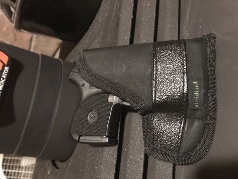 1993 Ford Bronco - A handgun is secured in a holster, with part of a cylindrical object visible.