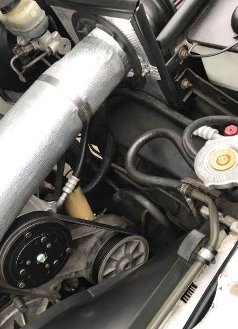 1995 Ford Bronco - Close-up view of the engine bay components, including the intake system and belt-driven accessories.