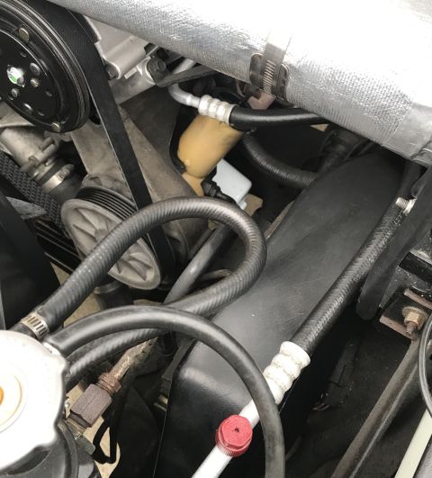 1995 Ford Bronco - Close-up view of various engine bay components, including hoses, belts, and pulleys.