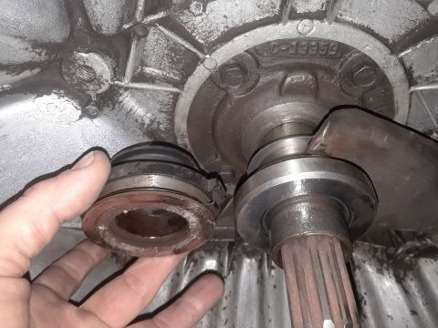 1985 Ford Bronco - Close-up of a clutch release bearing being held, with the transmission input shaft visible.
