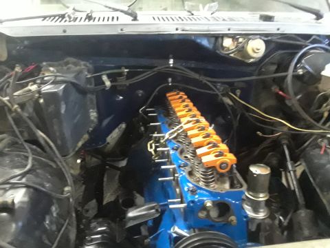 1985 Ford Bronco - Close-up view of a V8 engine, likely undergoing maintenance or rebuild, with prominent orange valve covers.