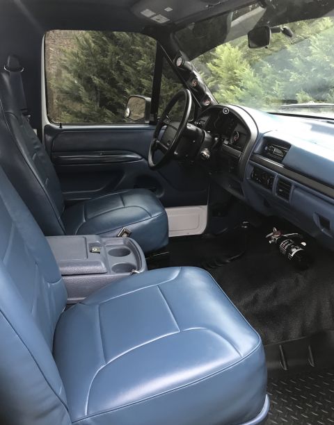 1995 Ford Bronco - Interior view of a 1995 Ford Bronco, showing the blue seats and dashboard.