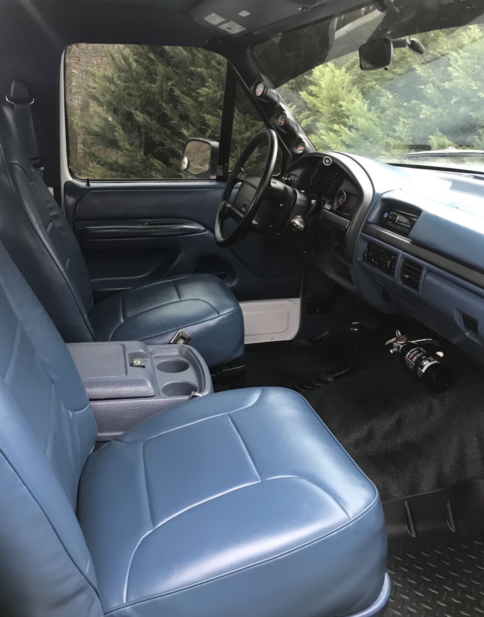 1995 Ford Bronco interior with blue seats, dashboard, and steering wheel