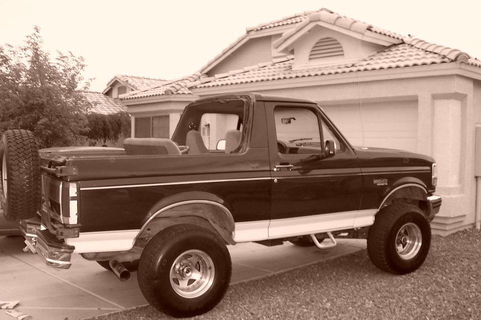 1992 Ford Bronco parked in driveway, spare tire on back