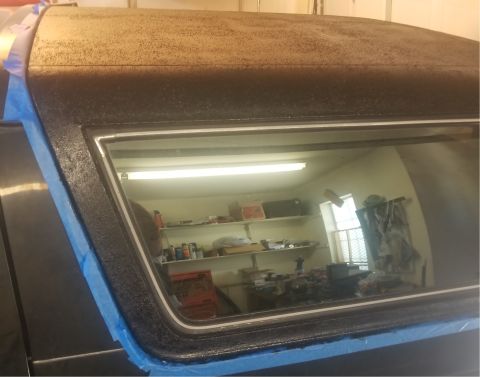1993 Ford Bronco - The rear window frame of a 1993 Ford Bronco is shown with blue masking tape applied, preparing for a textured roofline treatment.