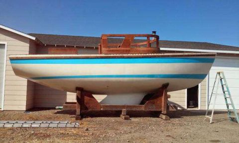1991 Ford Bronco - A boat is supported by a wooden stand in front of a building, with a ladder to the right.