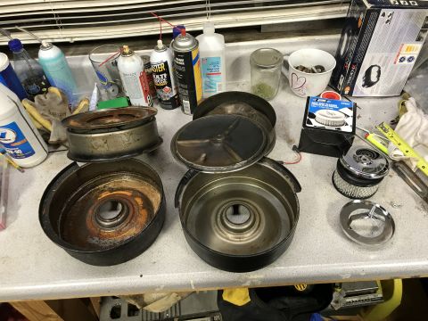 1991 Ford Bronco - Disassembled air cleaner components and a new filter are laid out on a workbench next to cleaning supplies.