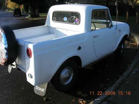 1991 Ford Bronco - A white pickup truck is parked on the side of a street, with a spare tire mounted on the rear.
