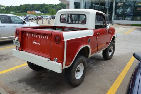 1991 Ford Bronco - International Scout pickup truck with a white cab and red body is parked in a lot.