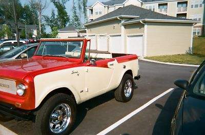 1991 Ford Bronco - This two-tone convertible SUV is parked in a lot next to another vehicle.