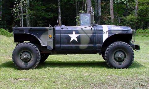 1991 Ford Bronco - Side view of a military truck with camouflage paint and MP markings.