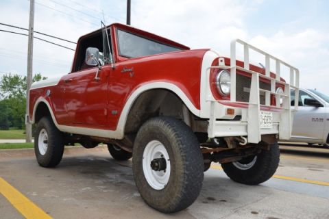 1991 Ford Bronco - This red and white pickup truck is parked on pavement with a yellow line. A second vehicle is visible to the right.