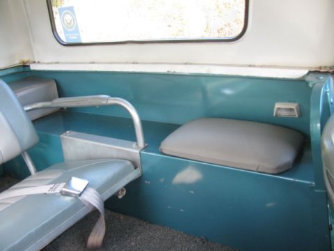 1991 Ford Bronco - Rear interior of an older SUV, showing teal painted panels and grey seats with a seatbelt.