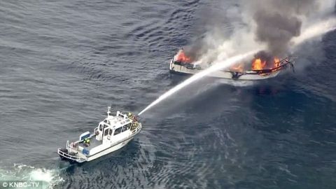 1991 Ford Bronco - A boat is dousing another vessel engulfed in flames at sea.
