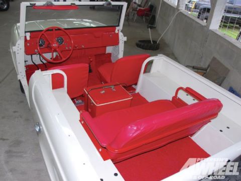 1991 Ford Bronco - Interior view of a white convertible with a bright red interior, including seats, floor mats, and dashboard.