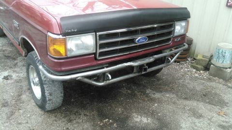 1991 Ford F-150 - Front view of a red Ford F-Series truck with a custom bumper and bug deflector.