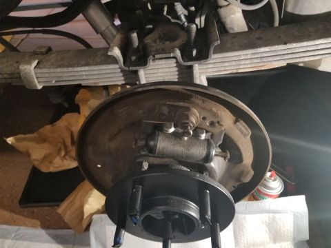 1993 Ford Bronco - Close-up of a vehicle's rear drum brake assembly, showing the brake cylinder and drum.