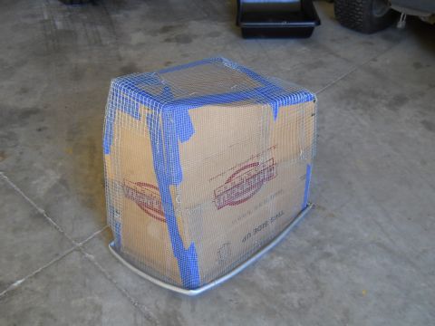1992 Ford Bronco - A box, possibly a part, is covered in wire mesh and tape, sitting on a concrete floor.