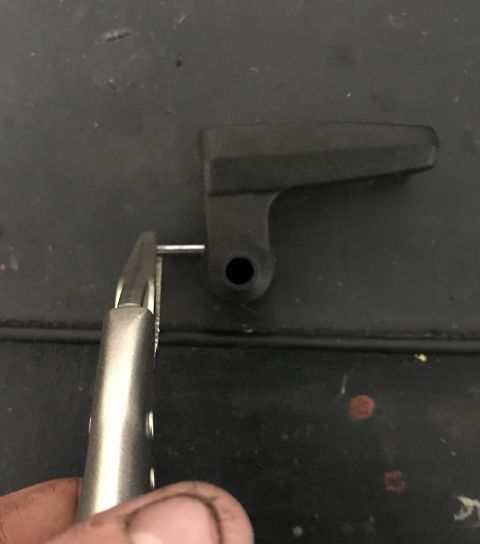 1995 Ford Bronco - A black plastic lever with a metal pin is held by pliers against a dark surface. Text at the bottom reads "SUPERMOTORS www.supermotors.net".